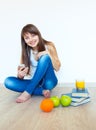 Young girl with headphones and green apple listening music at ho