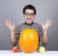 The young mad men try to eat apples and pumpkin.