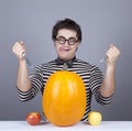 The young mad men try to eat apples and pumpkin.