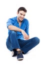 Young Man Sitting Against Whit...
