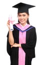 Woman with graduation cap and gown with arm raised holding diplo