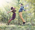 Young woman and man in bright clothes jumping to meet each other