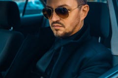 Elegant male in black suit driving car Royalty Free Stock Image