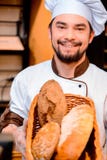 Handsome cook in the kitchen Royalty Free Stock Photography - handsome-cook-kitchen-proud-his-baked-goods-cropped-image-young-man-apron-holding-basket-baked-goods-bakery-50488287
