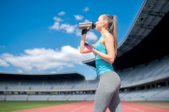 healthy-fitness-girl-drinking-protein-shake-workout-stadium-portrait-53567841.jpg