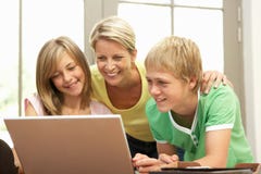 Mother And Teenage Children Using Laptop At Home Stock Image