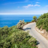 Mountain highway with blue sky and sea Stock Photo