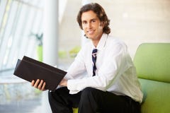 Portrait Of Businessman Sitting On Sofa Reading Report Royalty Free Stock Images