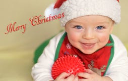 Smiling toddler wishes Merry Christmas Stock Photo - smiling-toddler-wishes-merry-christmas-happy-baby-beautiful-blue-eyes-wearing-cap-bib-holding-ball-64446500