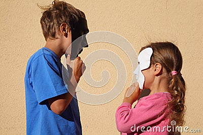 女孩和男孩戴着屏蔽并且查看彼此 库存照片 - 