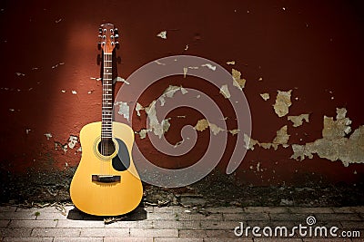 Acoustic guitar against grungy wall