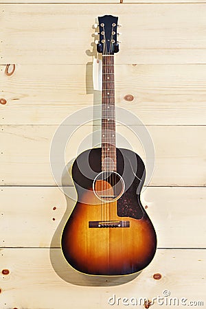 Acoustic guitar with label isolated on a wood grain wall