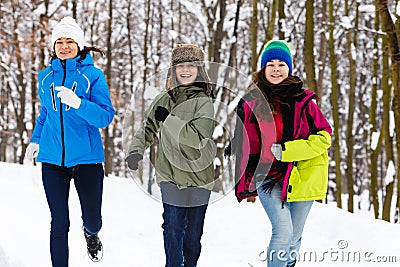 Active family - mother and kids running outdoor in winter park