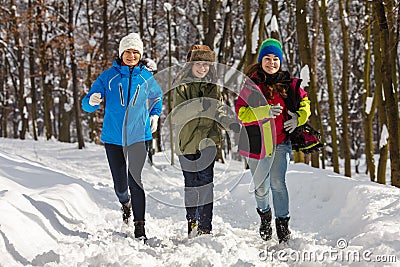 Active family - mother and kids running outdoor in winter park