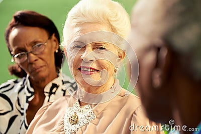 Group of elderly black and caucasian women talking in park