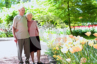Active senior couple in beautiful flowers park
