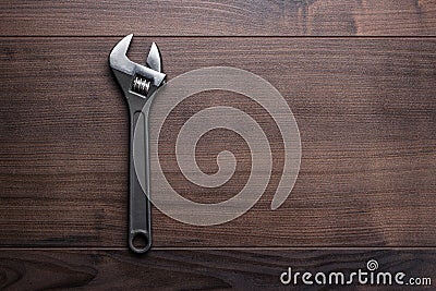 Adjustable wrench on the wooden background
