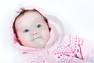 Adorable baby girl in pink knitted jacket with red hearts