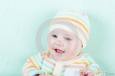 Adorable laughing baby wearing a warm knitted jack