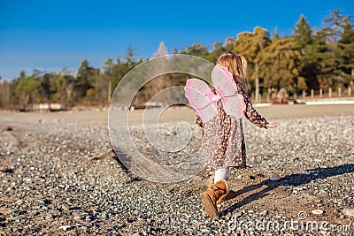 Adorable little girl with butterfly wings running
