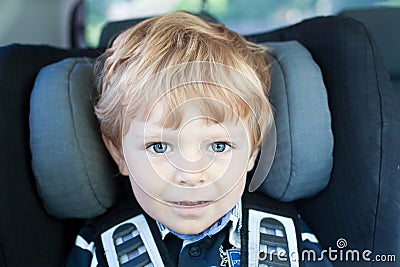 Adorable toddler with blue eyes in safety car seat