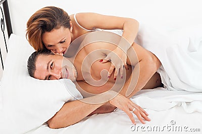 Adult lovers kissing in bed