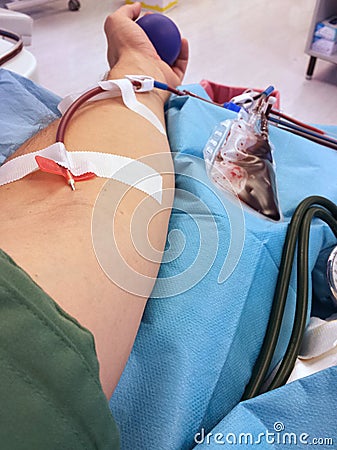 Adult man s arm during the blood collection to the hospital