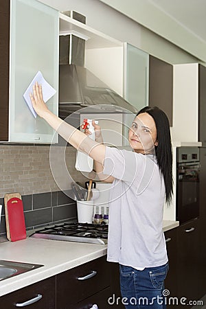 Adult woman cleaning furniture on the kitchen