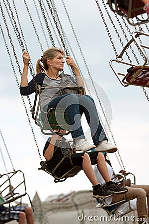 Adult Woman Rides Swings At County Fair