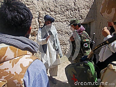 Afghan military officer interrogating a local