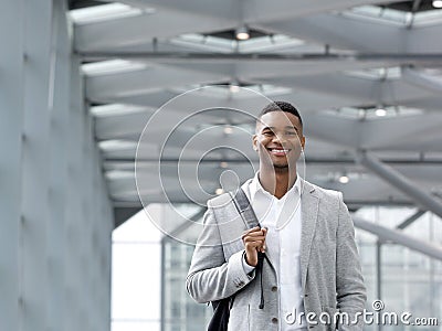 African american man smiling with bag at airport