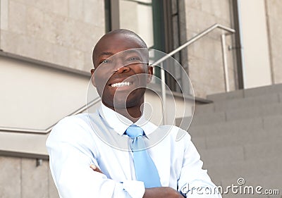 African businessman on stairs laughing at camera