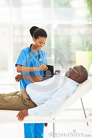 African nurse measuring blood pressure