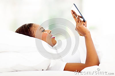 African woman in bed using tablet