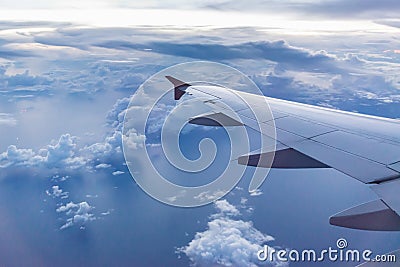 Aircraft wing on the clouds, flying evening background