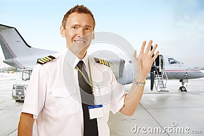 Airline pilot at the airport waving