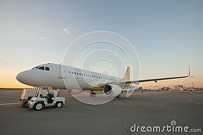 Airplane on airport runway at sunset