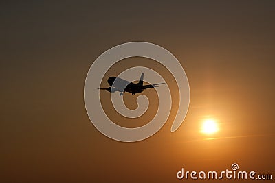 Airplane landing at sunset