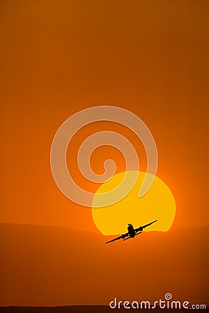 Airplane taking with bright orange sunrise