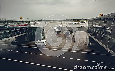 Airport terminal with airliners at boarding gates at rainy day