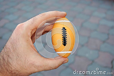 American football ball in hand