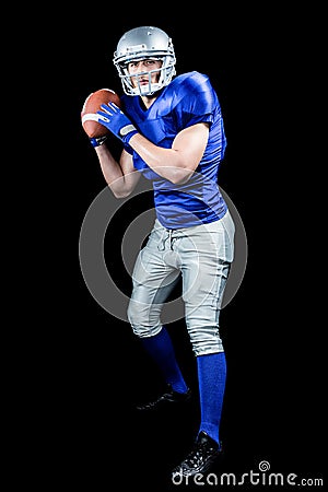   Photo: American football player throwing ball over black background  football background portrait