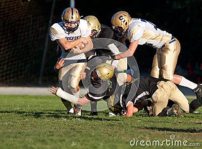 American Football Players Tackle During a Game