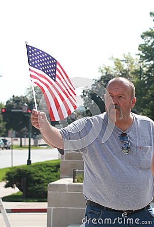 American Man waves US flag at Rally to Secure Our Borders