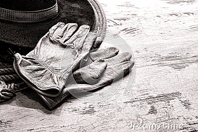  cowboy hat atop a vintage lasso lariat over grunge wood planks ranch