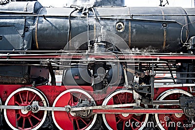 Ancient steam locomotive in steam. Live steam around mechanical