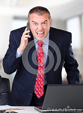 Angry businessman screaming into the mobile phone