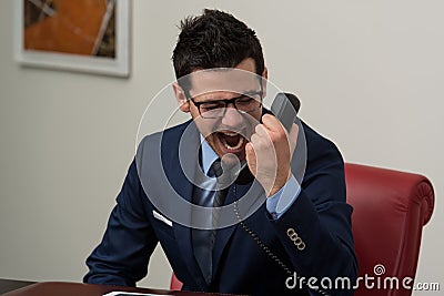 Angry Businessman Yelling Into A Cellphone