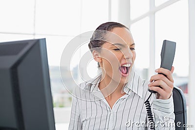 Angry businesswoman screaming at phone