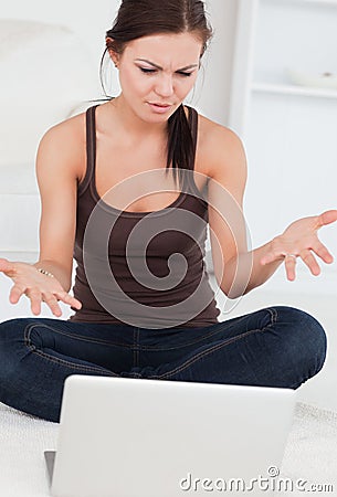 Angry dark-haired woman using her laptop